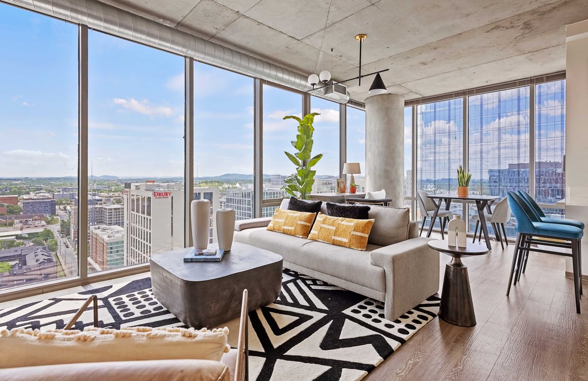 Living and dining area with floor to ceiling windows.