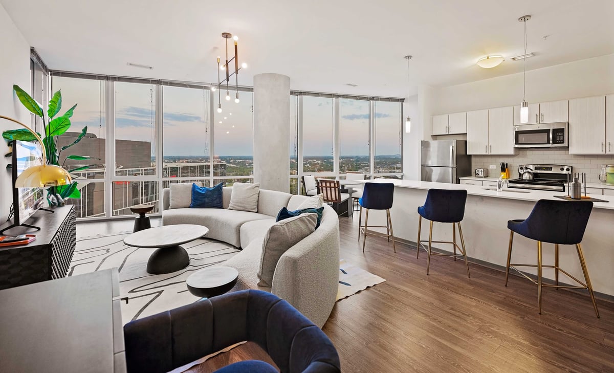 Modern, spacious living area with open kitchen.