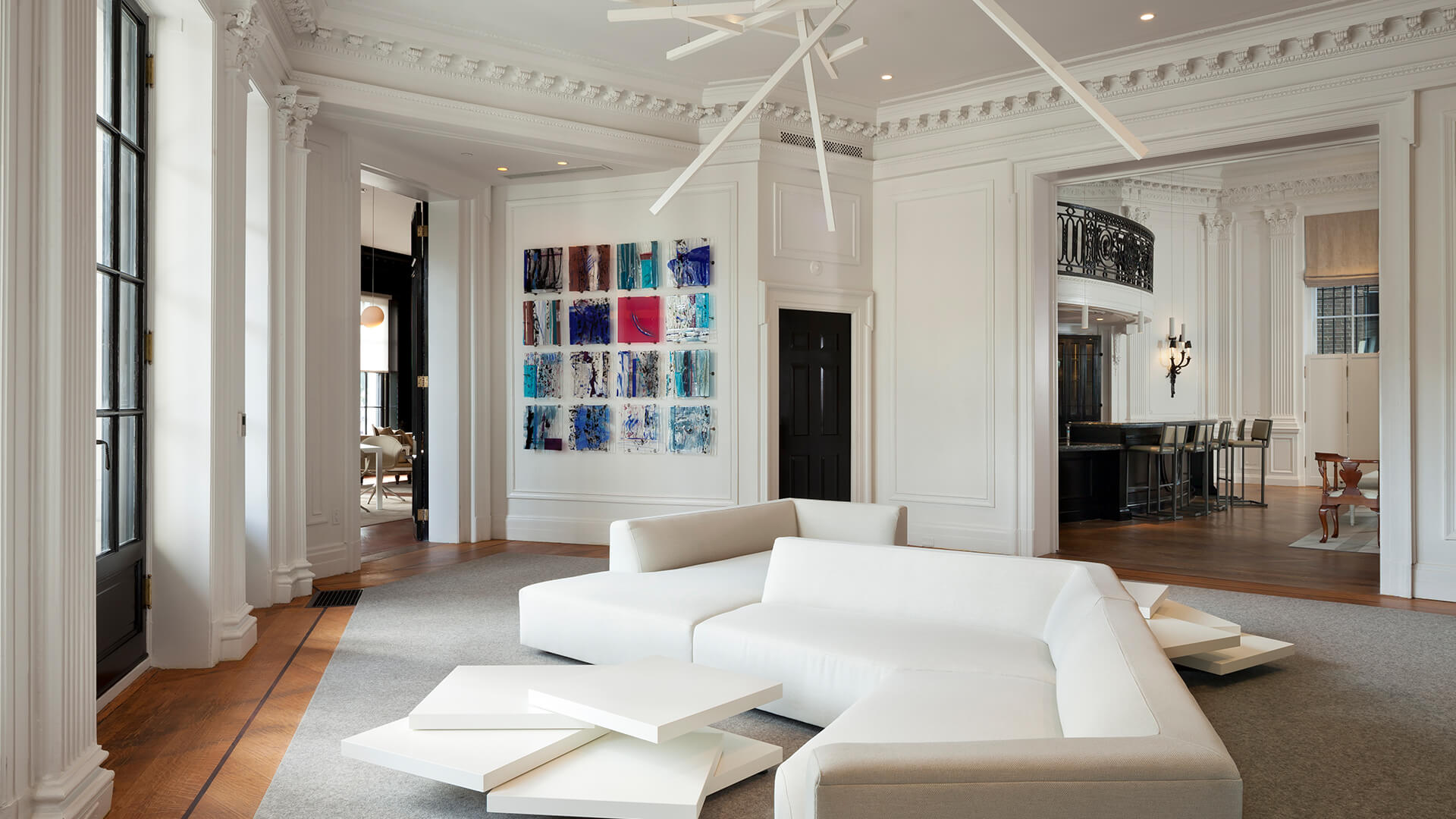 Modern lounge at Placemakr Dupont Circle featuring contemporary art, sleek white furniture, and original architectural details.