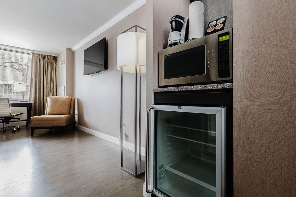 Kitchenette with refrigerator, microwave, and coffee maker. 