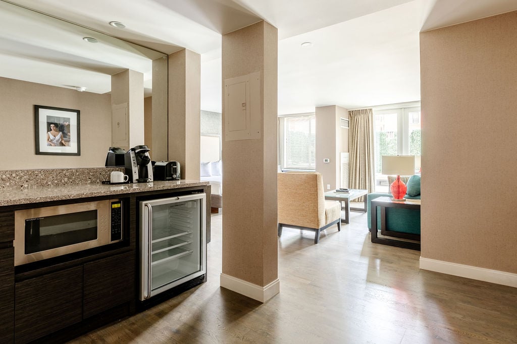 Seating area and kitchenette with refrigerator, microwave, and coffee maker. 