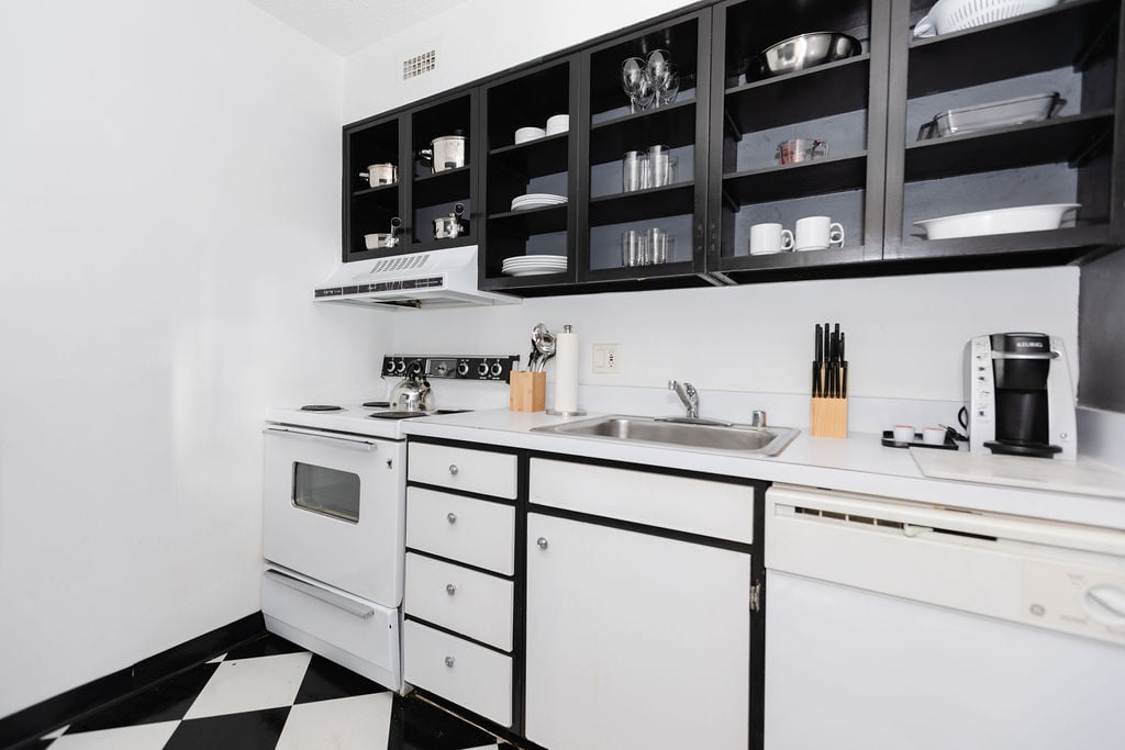 Full kitchen with flatware, cutlery, and coffee maker.