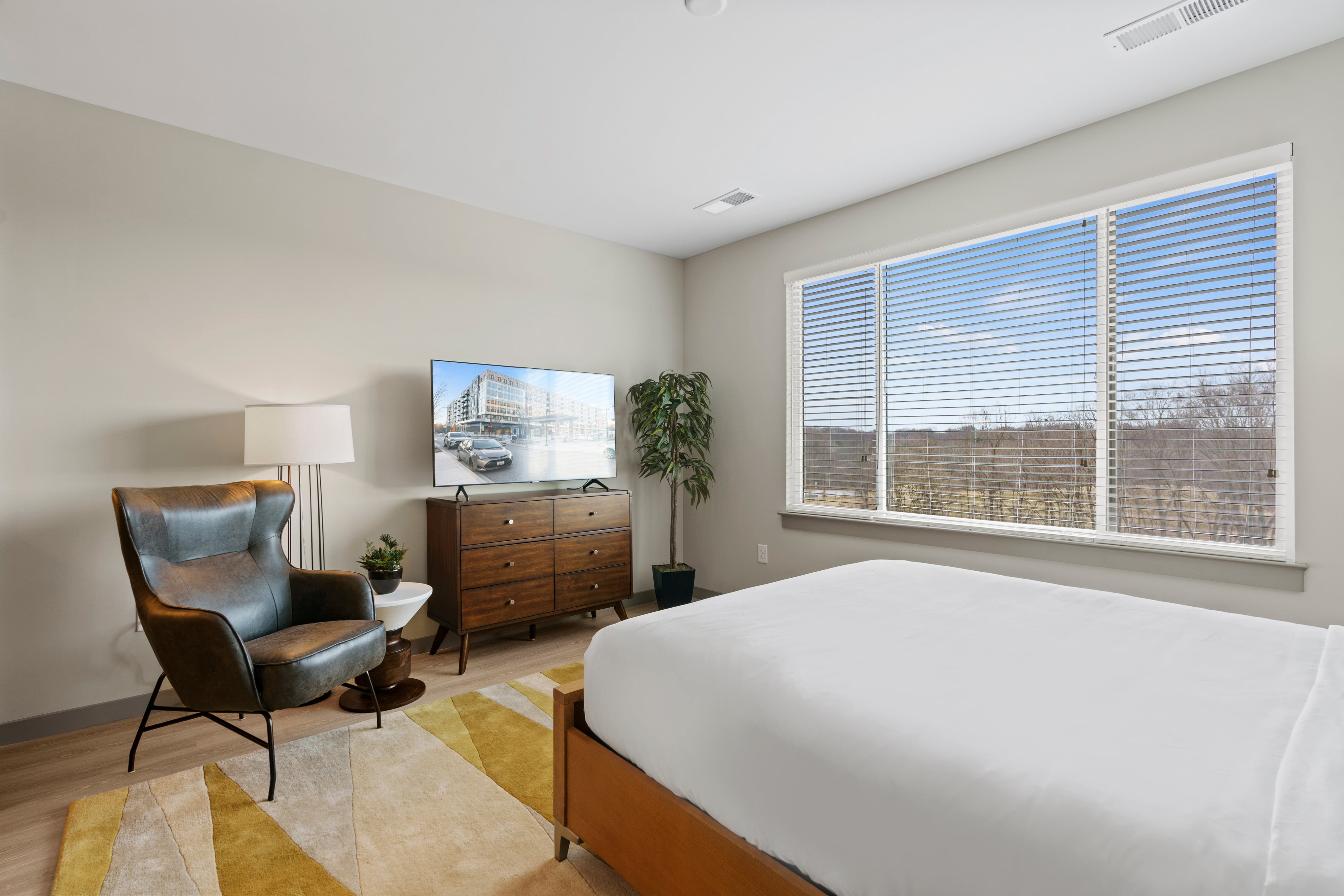 Bedroom with chair and television. 