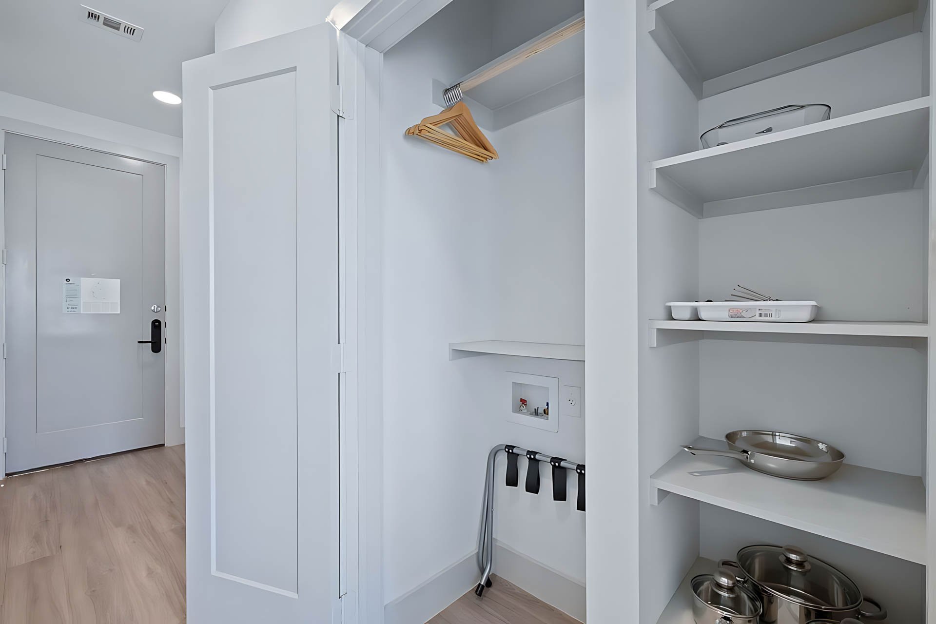 AUTX002_Guestroom_One Bedroom Apartment_Entry_Closet with hangers kitchenware