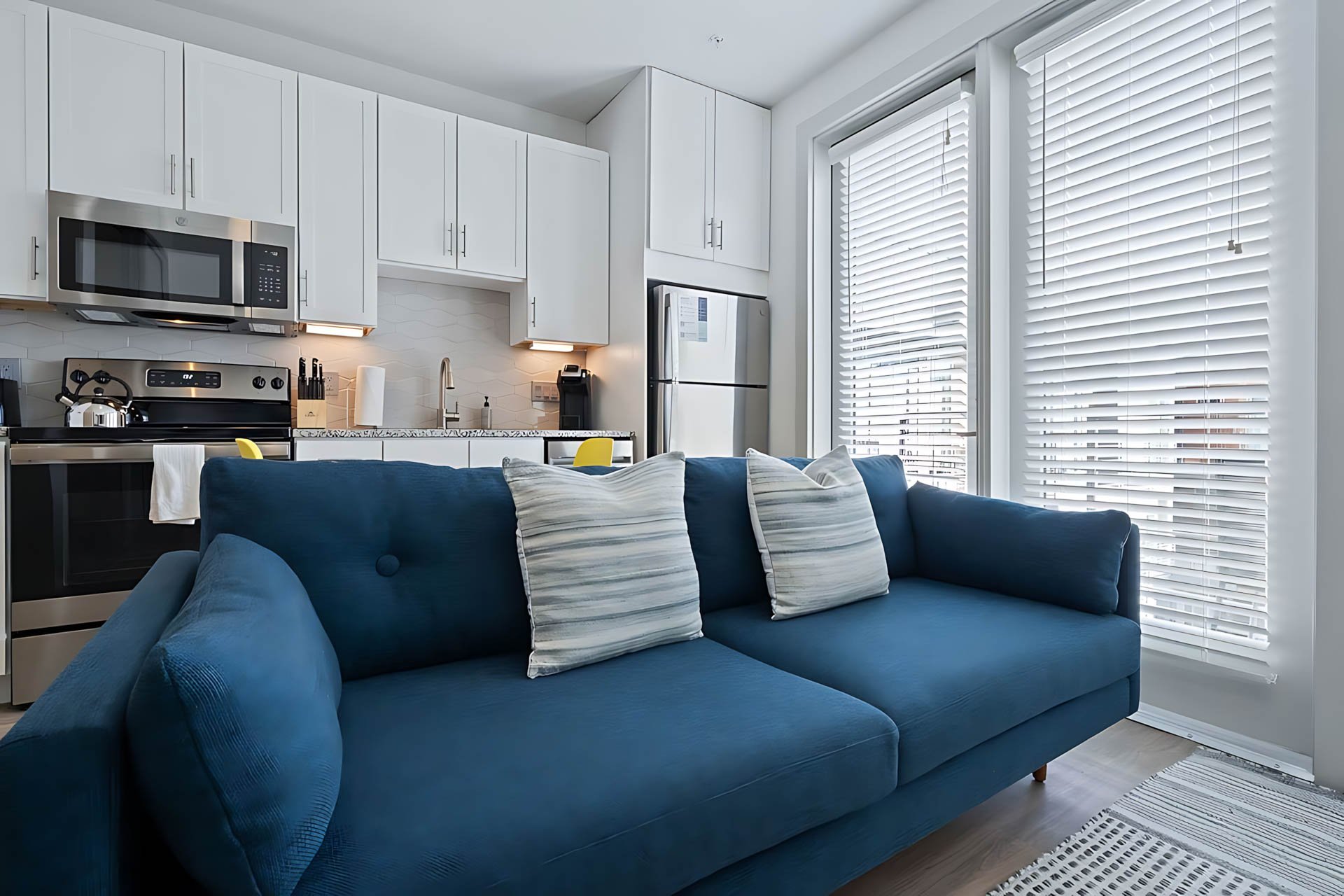 AUTX002_Guestroom_One Bedroom Apartment Accessible_Lounge Area_Blue sofa kitchen view