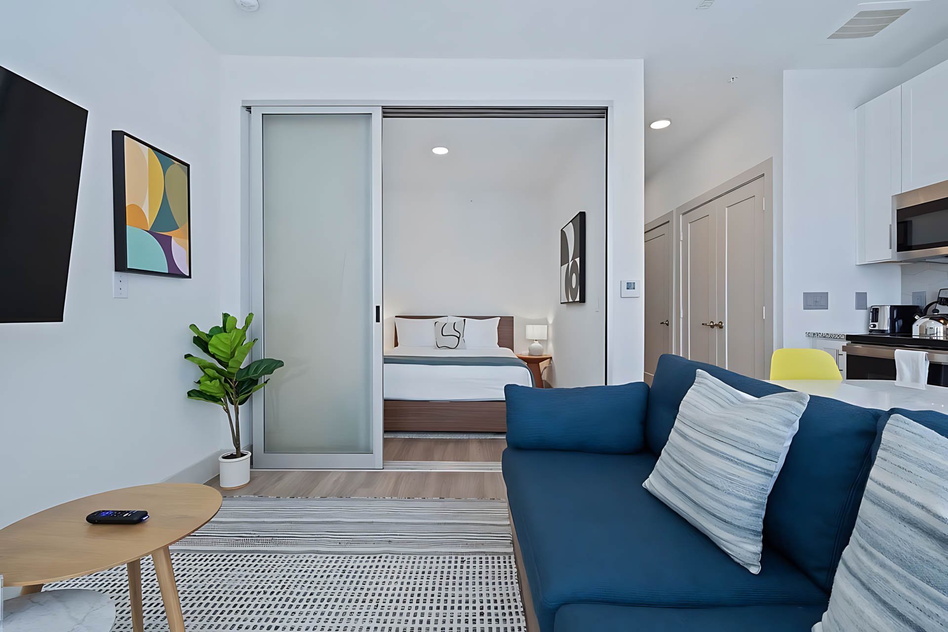 AUTX002_Guestroom_One Bedroom Apartment Accessible_Lounge Area_Blue sofa sliding doors