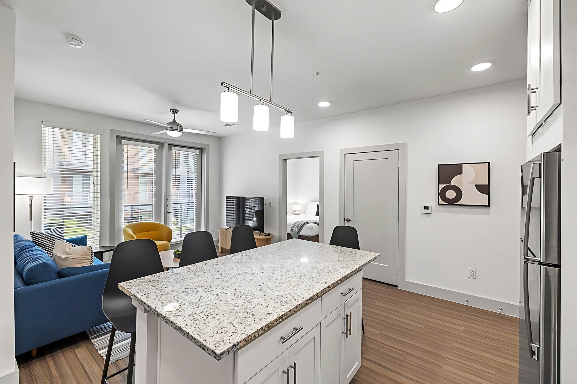 AUTX002_Guestroom_Premium Two Bedroom Apartment_Kitchen_Granite island black chairs