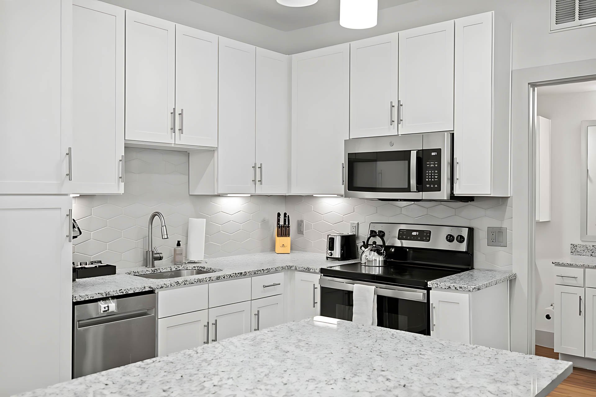 AUTX002_Guestroom_Premium Two Bedroom Apartment_Kitchen_White cabinets granite countertops