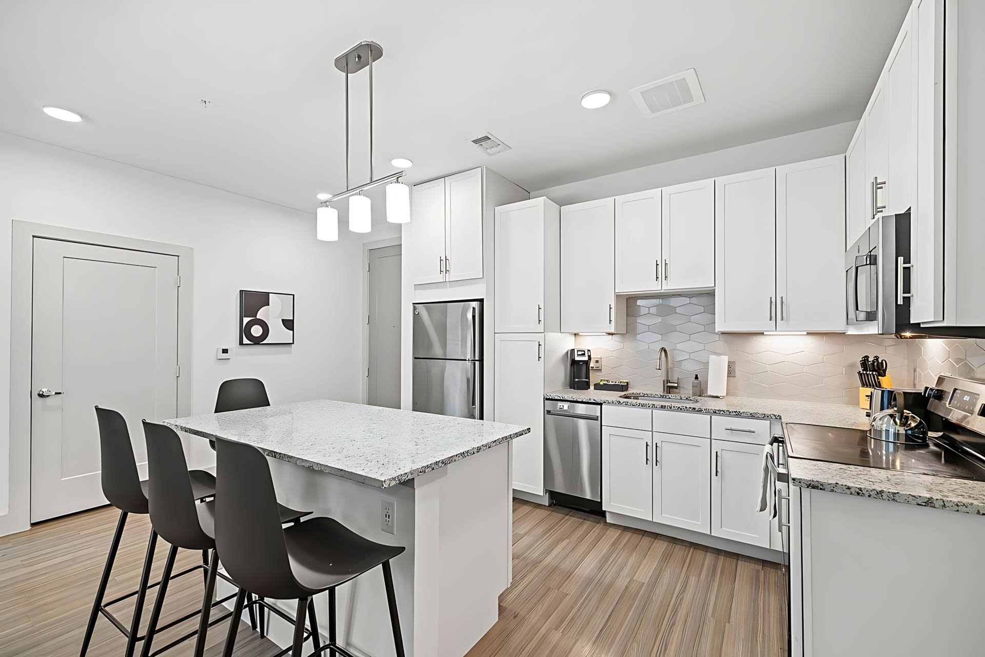 AUTX002_Guestroom_Premium Two Bedroom Apartment_Kitchen_Granite island black stools