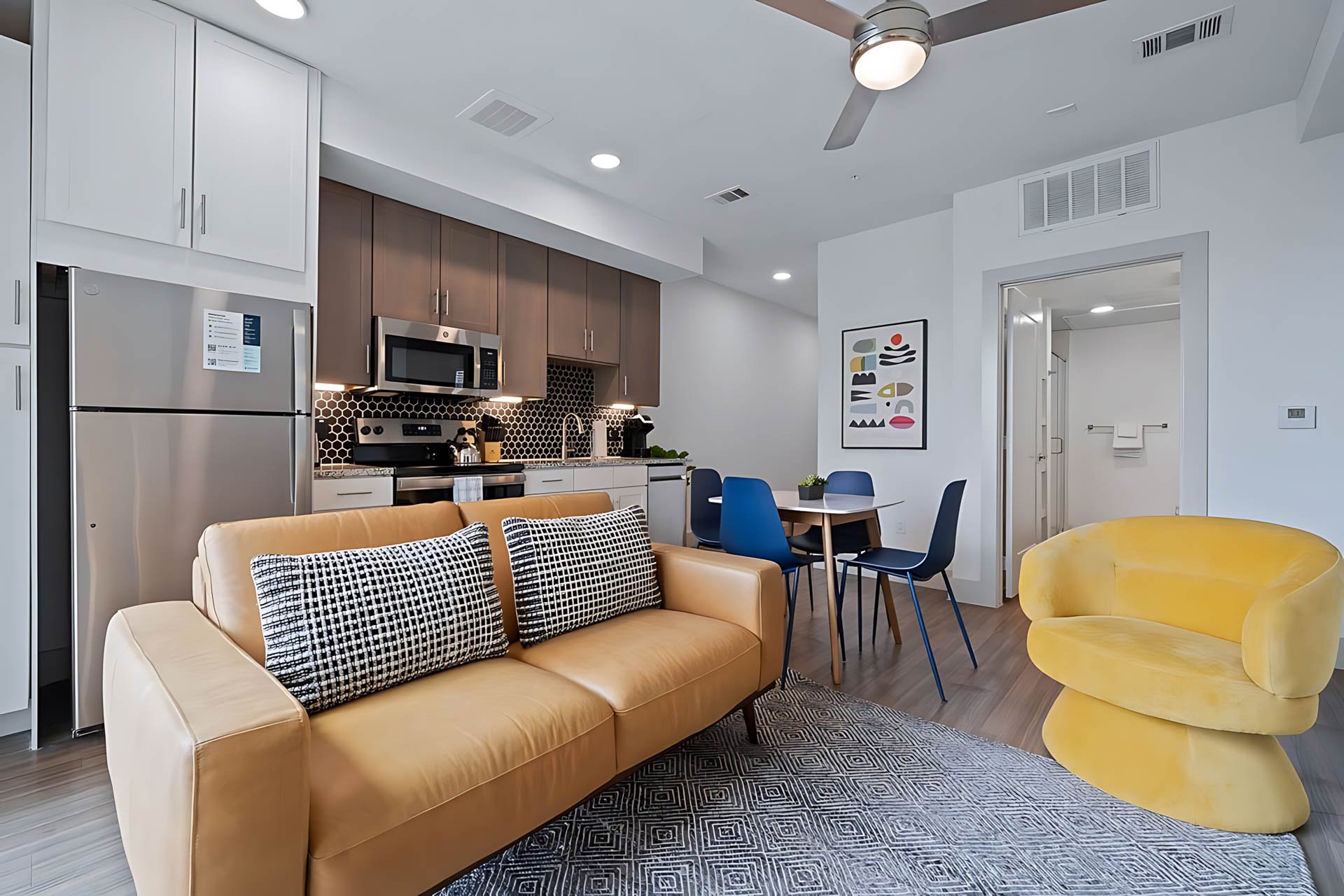 AUTX002_Guestroom_Two Bedroom Apartment_Lounge Area_Leather sofa yellow armchair