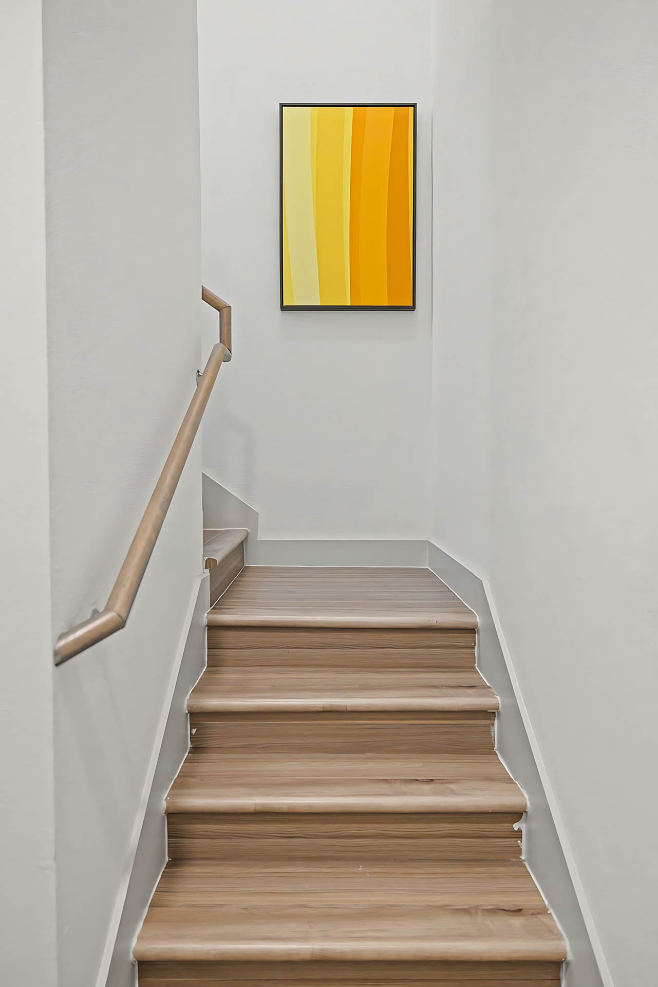 AUTX002_Guestroom_Two-story Two Bedroom Apartment_Entry_Wooden stairs handrail artwork