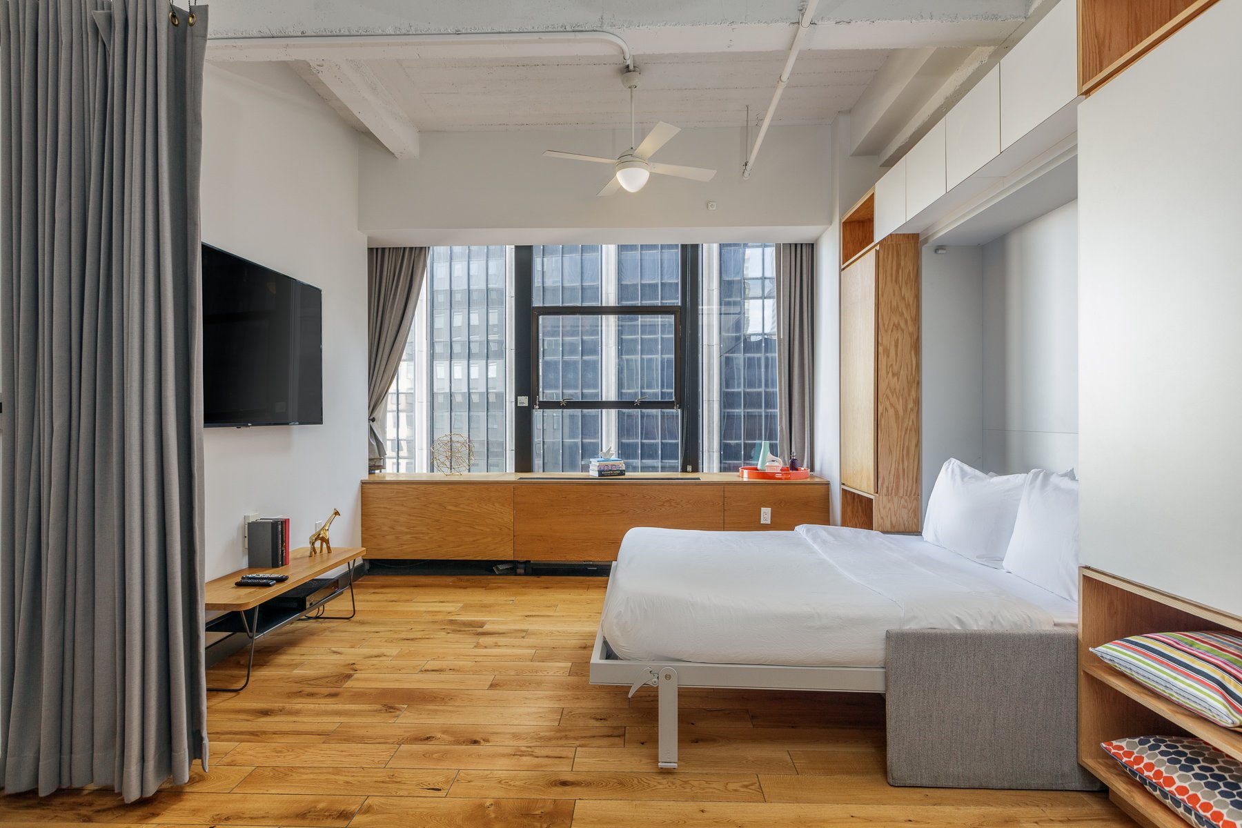 Murphy bed, television, and city views. 
