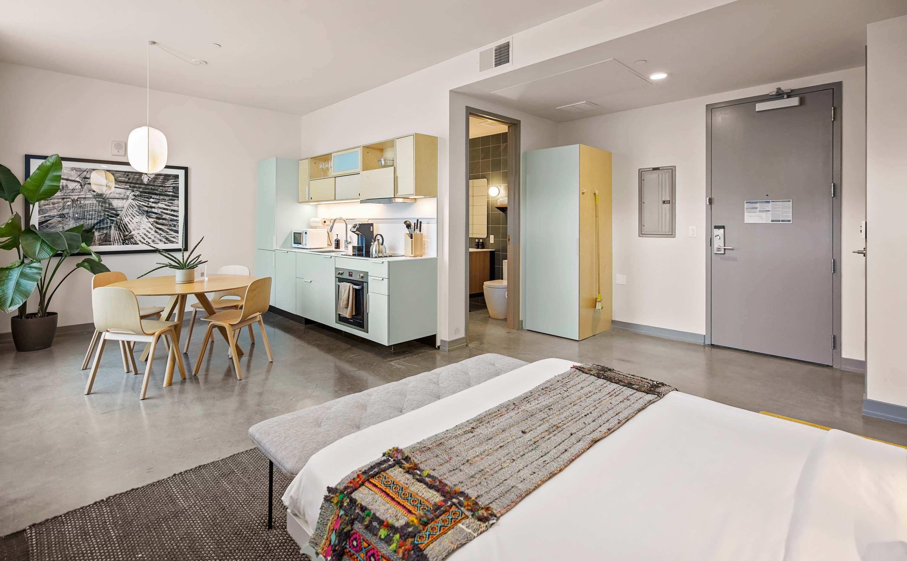 Murphy bed with kitchenette and dining space.